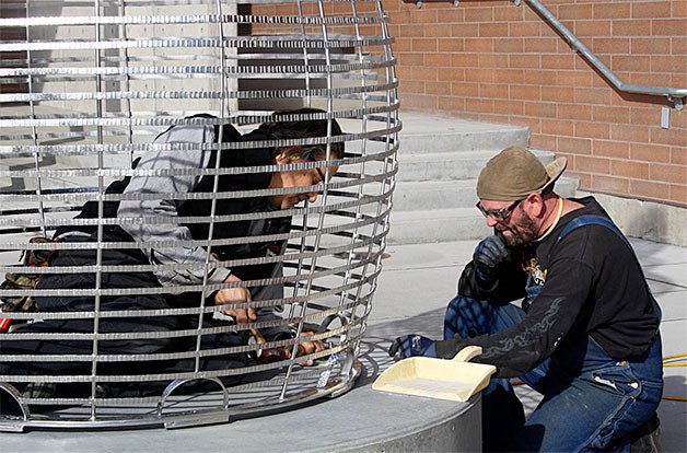 Artist Ries Niemi and Friend Holloway install two new statues at Oak Harbor High School Thursday