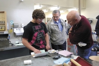 City Councilman Rick Almberg and Mayor Jim Slowik watch as student Drew Culver work on a small