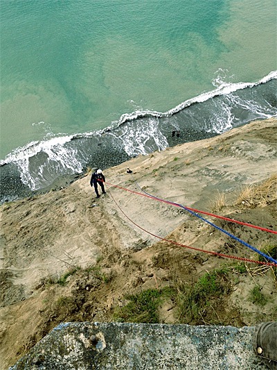 Firefighter Todd Bassett descends down a West Beach cliff to rescue a young man who had fallen last Sunday.