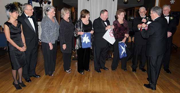 Past Commodore Steppe Williford presents the bridge with their burgees and inducts the Oak Harbor Yacht Club trustees and bridge. From left are Lori Rhodenbaugh