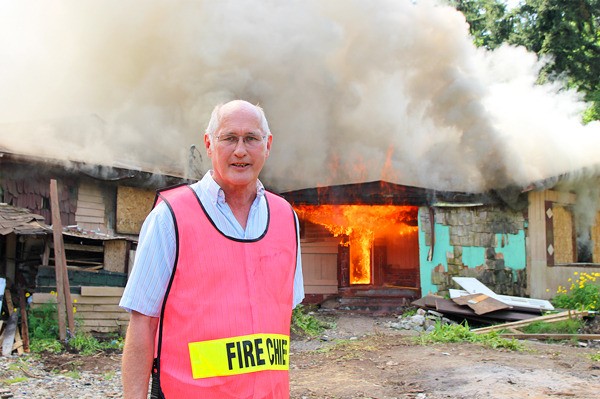 Marv Koorn stands in front of a house the fire department burned for practice earlier this year.