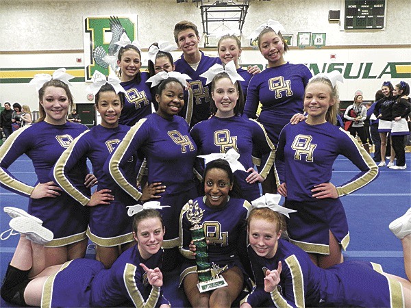 The Oak Harbor cheer team displays its first-place trophy.