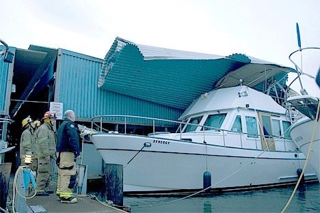Oak Harbor Fire Department Battalion Chief Ray Merrill and several firefighters survey the damage to Oak Harbor Marina's 'C' dock early Monday morning.