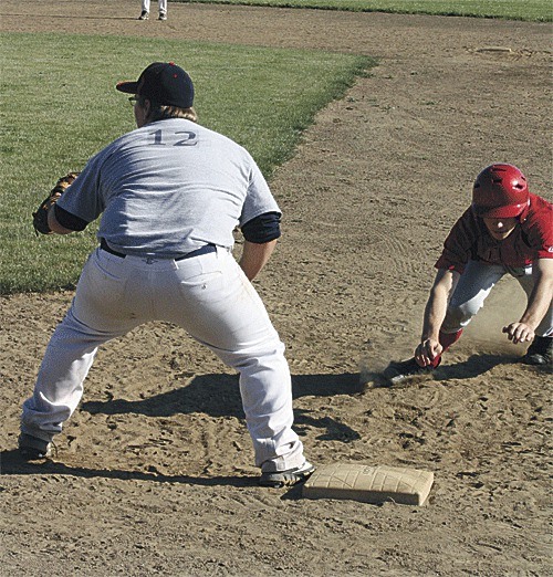 Coupeville's Wade Schaef dives safely back into first base against Snohomish.