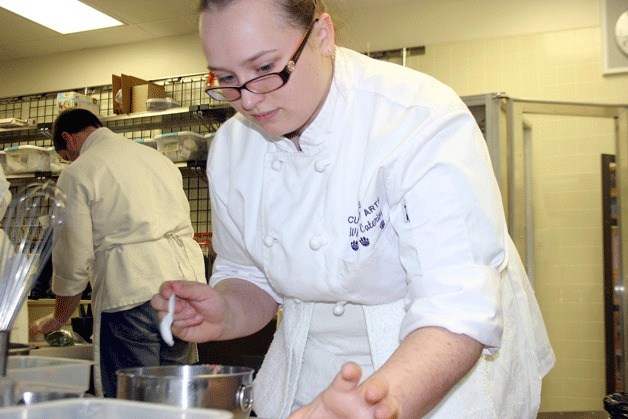 Oak Harbor High School senior and culinary arts team member Samantha Schortzmann cuts up meat during a practice cooking of the selected meal for this weekend’s state competition in Spokane.