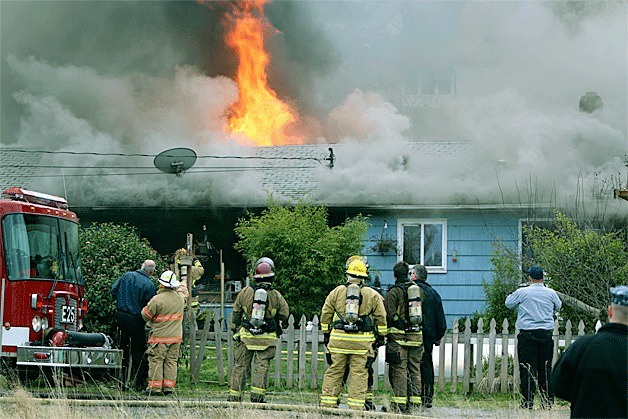 Firefighters fight a fire that was ablaze at a home Wednesday afternoon on Hawks Prairie Road.