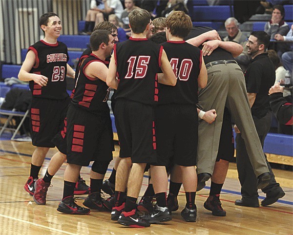 The Coupeville basketball team gives coach Anthony Smith a big hug after winning for the first time since 2011.