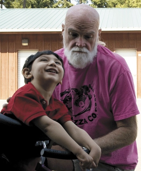 Three-year-old Gaius Roehnelt tests out a new piece of equipment with the help of his grandfather Rod.