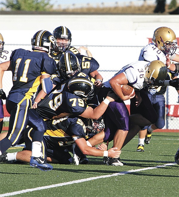 Oak Harbor's Brent Ryan (36) leaves a trail of Everett defenders in his wake as he battles for a first down. Ryan rushed for 226 yards and three touchdowns in the Wildcats' 47-14 win. Teammate Austyn Walker (40) helps out with a down-field block.