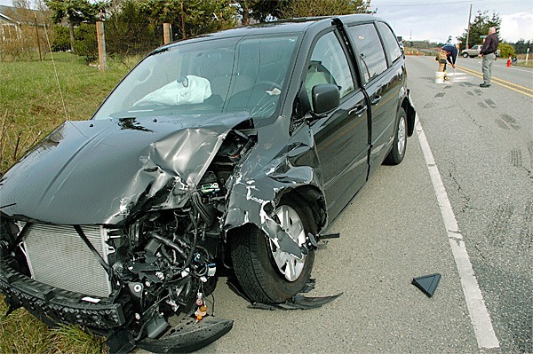 North Whidbey Fire and Rescue firefighters clean up after a two-car collision on Highway 20 and Holbrook Road Tuesday afternoon.