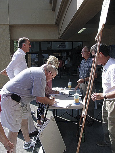 Former Island County commissioner Mac McDowell and City Councilman Bob Severns collect signatures on a hand-written petition at Walmart on Aug. 31.