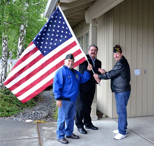 American Legion members Manny Valenzula and Dennis Jones present a new American flag to Oak Harbor Senior Services Director Mike McIntyre