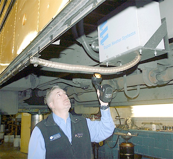 Oak Harbor School District director of transportation Francis Bagarella shows the pre-heaters recently installed under school buses to warm bus engines before they are started each morning.