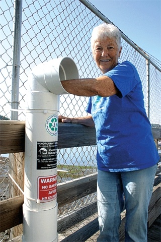 Jill Hein fishes around for monofilament line at the Oak Harbor Marina. She and her husband Clarence built the containers that are now situated at most fishing access spots on Whidbey Island. Recycling fishing line cuts down on litter and protects sea creatures.