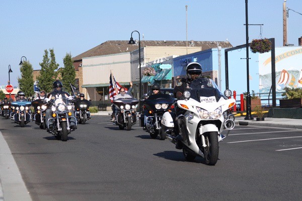 A motor patrol escorts a parade of Harley-Davidson riders through downtown Oak Harbor to kick off the Washington State H.O.G. Rally July 18