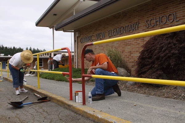 Steve Olson of Anacortes paints a rail at the front of Olympic View Elementary School in Oak Harbor July 17