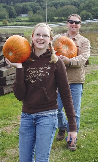 Kristen and Randy Ross carry pumpkins out of the patch at Dugualla Bay Farm north of Oak Harbor. In addition to the pumpkin patch