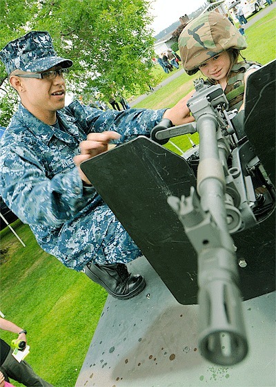 Master-at-Arms 3rd Class Mark Alvarez explains a M240B machine gun mounted on a High Mobility Multi-purpose Wheeled Vehicle (HMMWV) to Katelyn Leavell