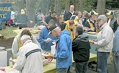 Coupeville Lions Club members feed the multitudes at last year’s salmon barbecue in Town Park.