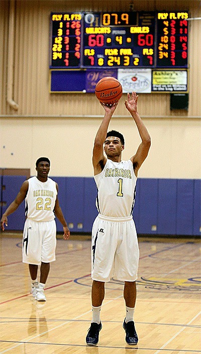 The scoreboard tells story as Dyllan Harris shoots to give Oak Harbor the lead. Harris made both free throws and the Wildcats defeated Arlington 62-61 Friday.