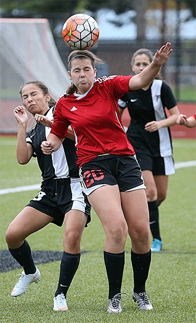 Mia Littlejohn (20) heads the ball for Coupeville in the Oak Harbor Jamboree Thursday.