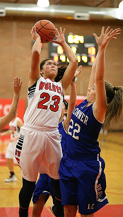 Makana Stone shoots over the defense of La Conner's Ashley Watkins.