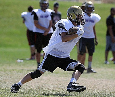 An Oak Harbor High School football player gains some ground at camp Thursday.