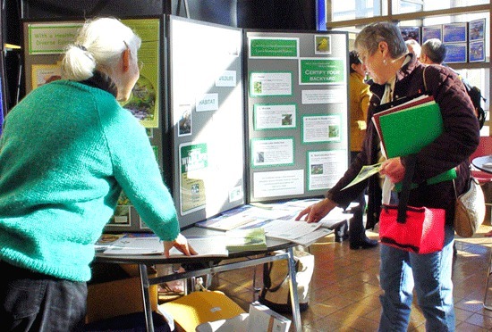 People browse the Whidbey Island Wildlife Habitat Project display at a local event.