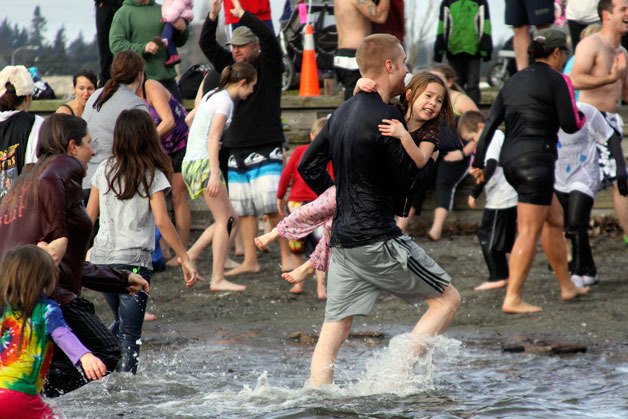 Participants make a quick exit from the chilly lagoon in Windjammer Park after the first polar bear plunge in Oak Harbor Jan. 1