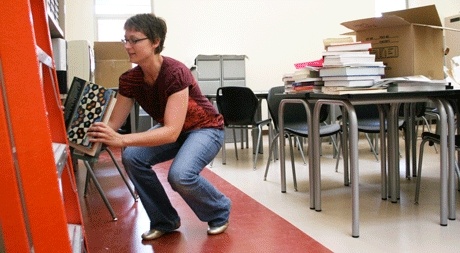 Oak Harbor High School math teacher Nicola Wethall files away books in her new classroom in the school’s B-wing.