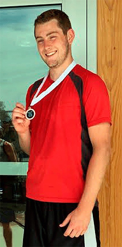 Aaron Curtin shows off his medal for placing eighth in the state singles tennis tournament.