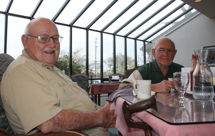 Harold Johnson and Joe Malsom enjoy a meal paid for by Social Security income at Harbor Tower Village.