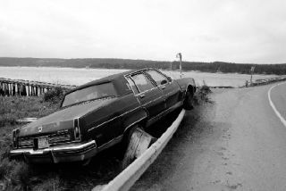 An Oldsmobile Ninety Eight is wedged up against a guardrail Friday morning in San de Fuca. Coupeville resident Earl Darst was driving south on Penn Cove Road when he lost his brakes and ran up the guardrail blocking the road from Highway 20