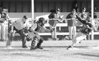 Out! Oak Harbor AA Legion catcher Brad Farnum has the plate blocked and prepares to put the tag on Burlington’s Dylan Boe in the seventh inning of Tuesday’s game.