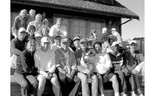 Participants and supporters in the Whidbey Island Tennis Cup competition gather as the North Whidbey team takes possession of the trophy. Holding the coveted cup is Willie Jenkins.