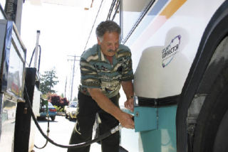 Frank Werfhorst fuels a large bus at Corey Oil in Coupeville. The consensus among transit officials is that charging fares won’t take the edge off skyrocketing fuel prices for Island Transit.