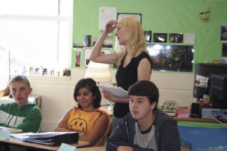 English Teacher Maya Kilmer gives directions to students while Kamille Basaca and Ryan Joslin listen.