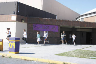 Their off! Members of the Oak Harbor High School boys cross country team bust out of the fieldhouse doors and head out for an afternoon of practice.