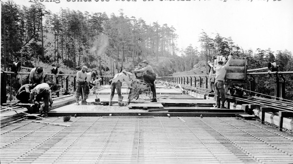 Construction crews work on the road surface of the Deception Pass Bridge in the months leading up to its opening in the summer of 1935.