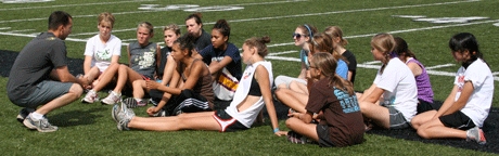 Coach Andy Wesley chats with the girls cross country team at Wildcat Memorial Stadium after a hard practice session.