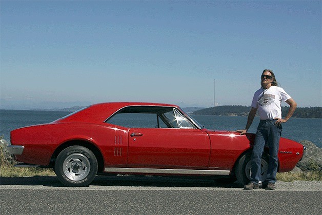 Scott Smith stands before a 1967 Pontiac Firebird that he restored and will bring to the North Whidbey Car Show Saturday. Smith has attended the show every year since it started in 1985.