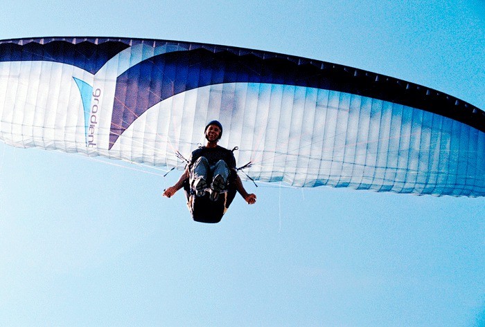 Bellevue resident Ross Jacobson cracks a smile while paragliding Wednesday afternoon. He was enjoying gliding along the northern edge of Penn Cove. Paragliding is a popular activity on Whidbey Island