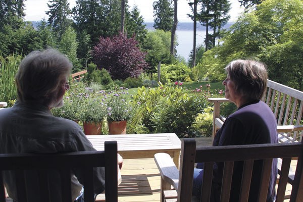 Tom and Sharon Vos share a rare moment of relaxation on their backyard patio that overlooks Saratoga Passage. The Vos’ Langley property is one of four residential gardens featured this year on the Whidbey Island Garden Tour