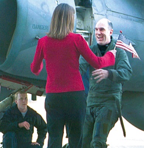 Lt. Cmdr. John Sheehan reaches out for his wife Laurie. The two embraced for the first time in almost seven months when members of VAQ-141 returned Friday from deployment aboard the USS Enterprise in the Middle East.