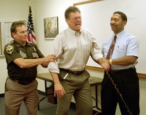 Staff photo / Jessie StenslandIsland County Sheriff Mike Hawley grimaces as he’s jolted by electricity from the department’s new Taser.