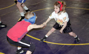 Six-year-old Kayla Miracle wrestles with Trenton Fadness at their wrestling club practice.