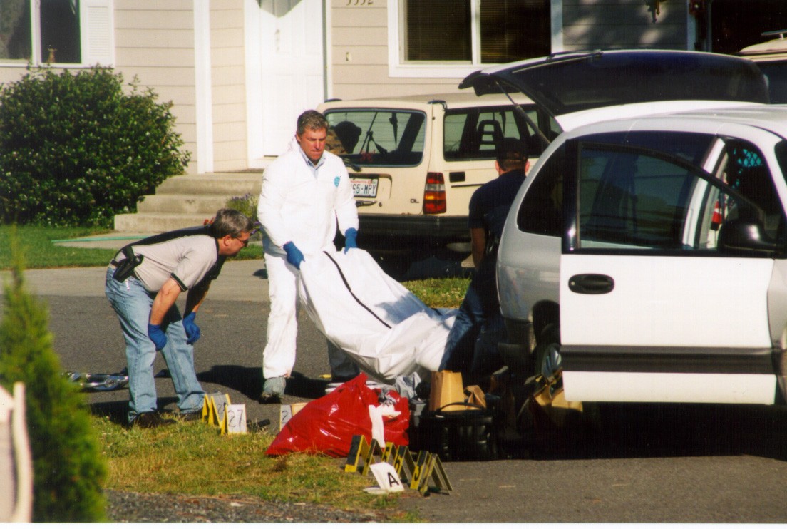 Island County Coroner Robert Bishop moves one of the victims of Thursday’s shooting in Freeland.