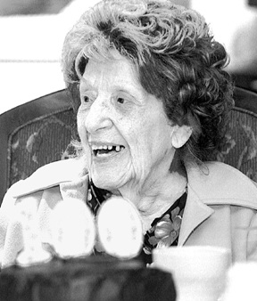 Ione Stanwick celebrates her 100th anniversary with a big piece of chocolate cake.