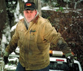 Bobby Neal of A-1 Towing emerges from the hole that a state DOT pickup slid into on Tuesday.