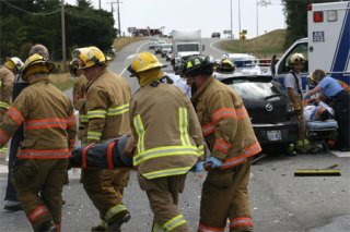 Emergency responders carry one accident victim to the ambulance Friday afternoon as others tend to the second victim. The accident occurred at Highway 20 and Ault Field Road.